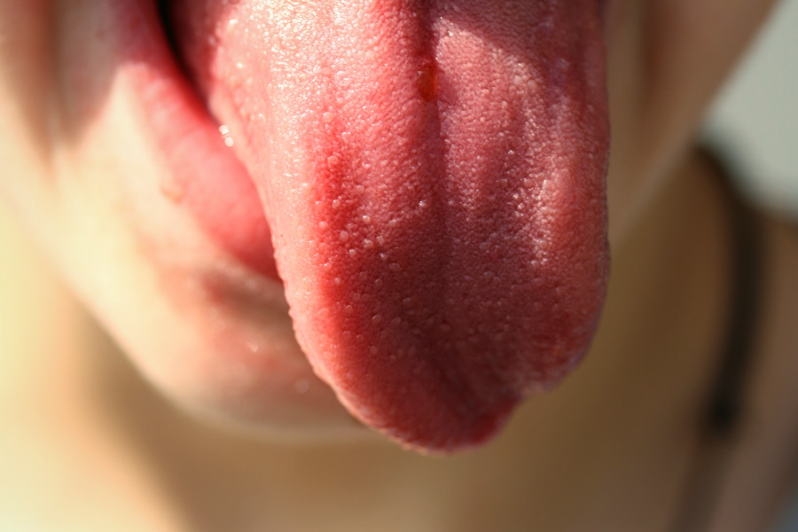 Closeup of a someone sticking out their pink tongue